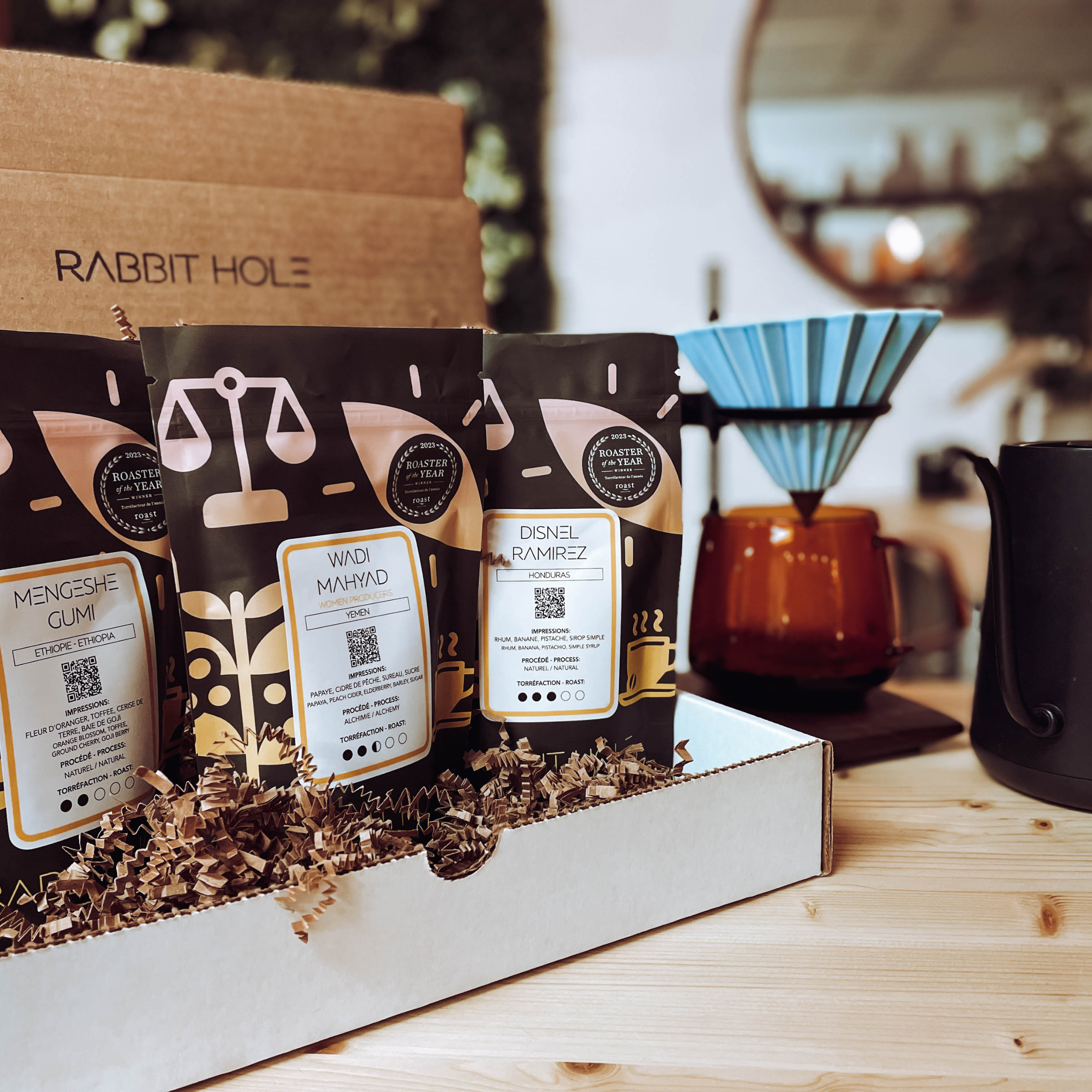Rabbit Hole Roasters opened gift experience box of coffee packages with pour over origami set and timemore kettle on their reception wooden unit.